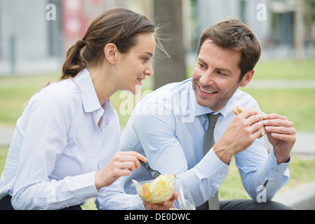 Mitarbeiter, die einem gemeinsamen Mittagessen im freien Stockfoto