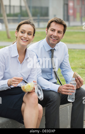 Mitarbeiter, die einem gemeinsamen Mittagessen im freien Stockfoto