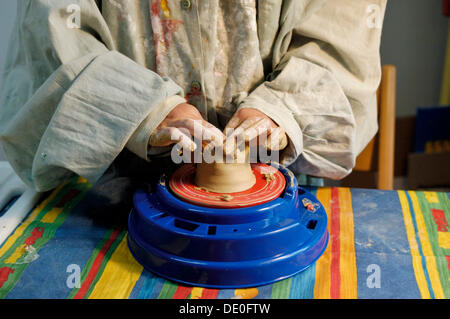 Kinderhände Töpfern, drehen ein Gefäß aus Ton auf einer Töpferscheibe Stockfoto