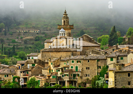 Dorf mit Regenwolken vor die Pfarrkirche Kirche Sant Bartomeu, Valldemossa, Region Comarca Serra de Tramuntana anzeigen Stockfoto