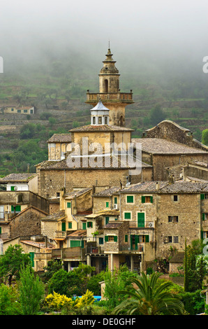 Dorf mit Regenwolken vor die Pfarrkirche Kirche Sant Bartomeu, Valldemossa, Region Comarca Serra de Tramuntana anzeigen Stockfoto