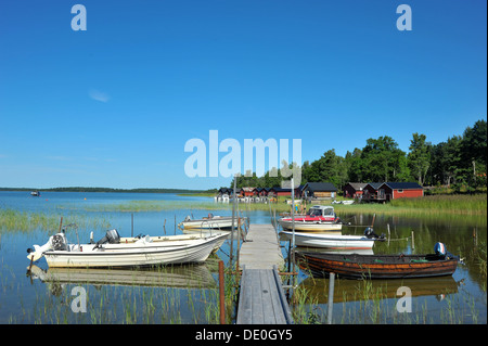 Die Reflexion der Boote gebunden an einen langen Ding Steg auf dem ruhigen Wasser der Ostsee. Stockfoto