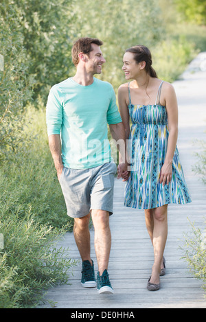 Paar Hand in Hand Spaziergang entlang der Promenade durch die Natur bewahren Stockfoto