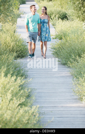 Paar Hand in Hand Spaziergang entlang der Promenade durch die Natur bewahren Stockfoto