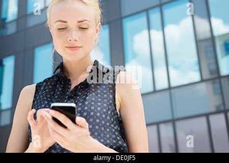 Junge Geschäftsfrau mit Smartphone im freien Stockfoto