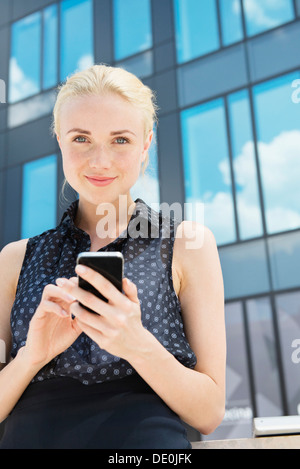 Junge Geschäftsfrau mit Smartphone im freien Stockfoto