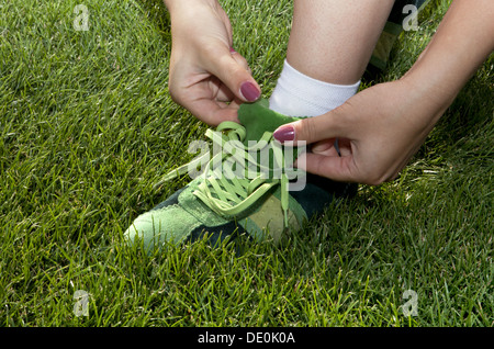 Frau fesselt Schnürsenkel auf den Sportschuhen Stockfoto