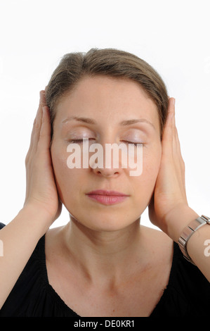 Junge Frau für die Ohren mit den Händen Stockfoto