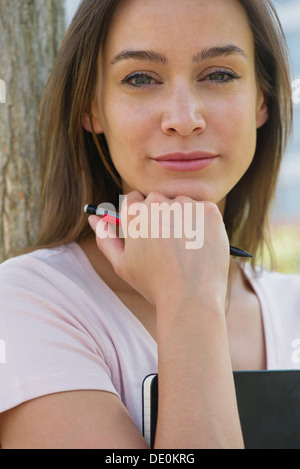 Frau mit Tagebuch, Hand unter Kinn, Porträt Stockfoto