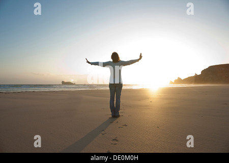 Frau mit ihrem ausgestreckten am Strand am Abend entspannen Stockfoto