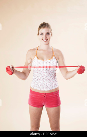 Junge Frau mit einem Theraband Übungen Stockfoto