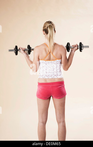 Junge Frau Krafttraining mit Hanteln Stockfoto