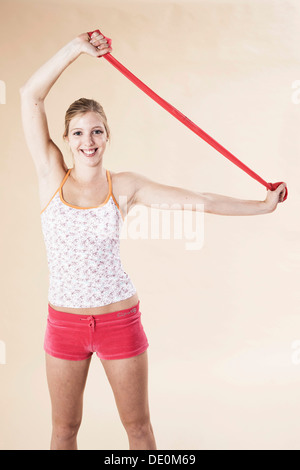 Junge Frau mit einem Theraband Übungen Stockfoto