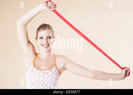 Junge Frau mit einem Theraband Übungen Stockfoto