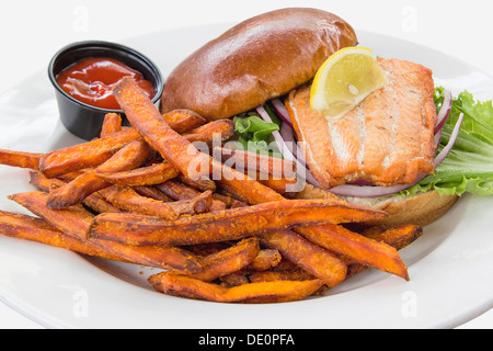 Lachs Fisch Steak Sandwich mit Zwiebel-Tomaten-Salat und Süßkartoffel-Pommes frites Stockfoto