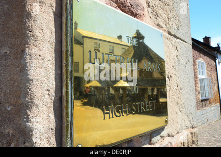 Die Garn-Markt spiegelt sich in The Luttrell Arms Plaque, High Street, Dunster, Somerset, England, Vereinigtes Königreich Stockfoto