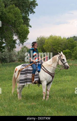 Krieger in Comanche Kleidung, weißes Pferd. Stockfoto