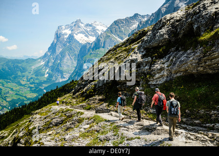 Wanderer auf dem Eiger-Trail in der Nähe von Grindelwald Schweiz mit Wetterhorn hinter Stockfoto