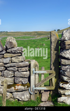 Wanderer durch Stil am Stadtrand von Dorf Grassington auf dem Dales Weg Langdistanz Fußweg gesehen. Stockfoto