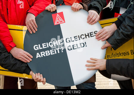 Hände mit Schild: "Gleiche Arbeit? Gleiches Geld! ", Deutsch für" gleiche Arbeit? Gleicher Lohn! ", Aktionstag gegen vorübergehende Stockfoto