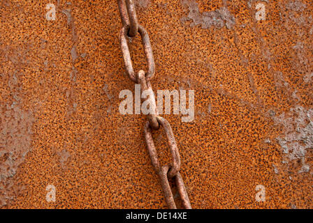 Rostige Kette vor rostigen Metallwand Stockfoto