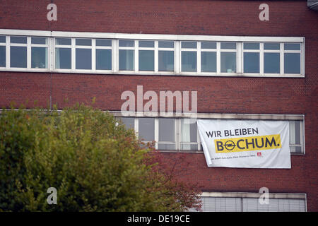 Ein Plakat mit der Nachricht "Wir bleiben Bochum" hängt im Opel-Werk in Bochum, Deutschland, 10. September 2013. Die Mitarbeiter forderte bei einem Werke treffen Opel qualifizierte Arbeitsplätze in der Region finden sollte, wenn die Pflanze am Ende des Jahres 2014 geschlossen werden. Das Werk beschäftigt derzeit 3.000 Menschen. Foto: FEDERICO GAMBARINI Stockfoto