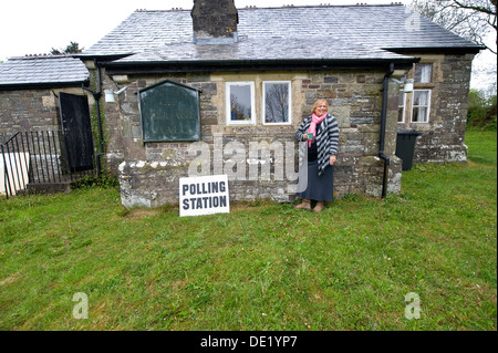 Umfrage Sekretärin Karen Holme außerhalb einer alten ländlichen Wahllokal an Stoke Flüssen, Devon während Wahlen Stimmen UK Stockfoto