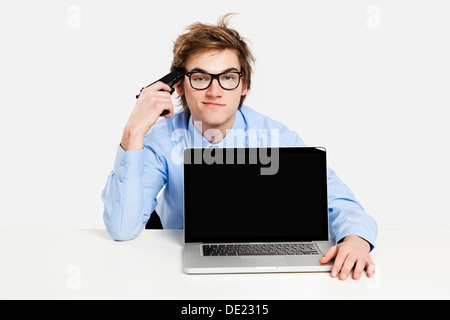 Müde Geschäftsmann im Büro und mit einer Pistole auf seinen Kopf Stockfoto