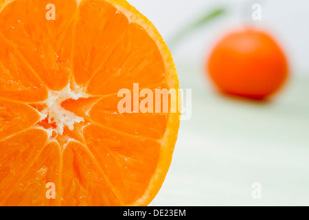 Ein schönes Stillleben Anordnung von Sevilla Orangen mit grünen Blättern auf ein Schneidbrett aus Holz Stockfoto