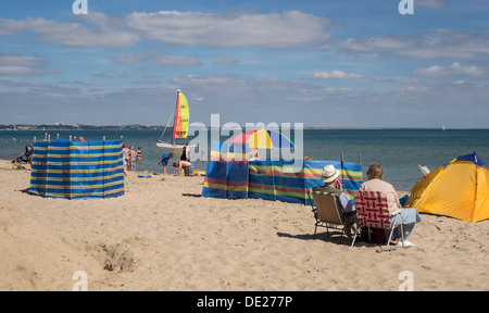 North Beach mit Paar in der Nähe von Windschutz entspannt, Isle of Purbeck, Dorset, England, UK. Stockfoto