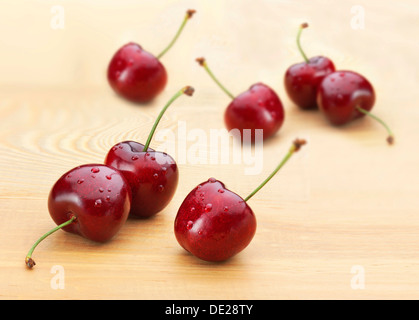 Kirschen (Prunus Avium), Tau fällt, auf einem Holzbrett Stockfoto