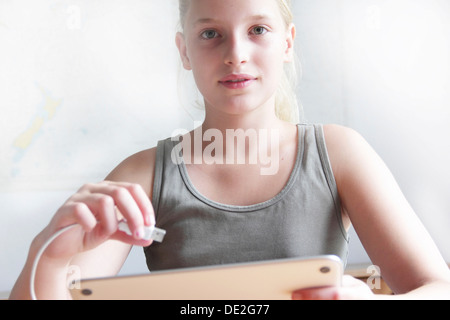 Mädchen hält ein iPad und einen USB-Anschluss Stockfoto