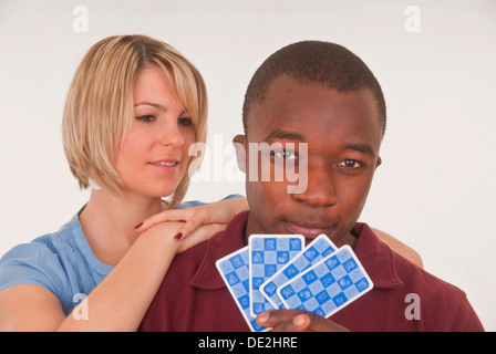 Dunkelhäutige junge Mann und junge Europäerin Spielkarten Stockfoto