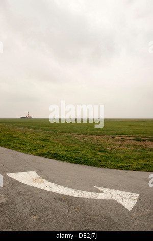 Weißen Richtungspfeil auf einer Straße nahe Westerhever Leuchtturm, Westerheversand, Eiderstedt, Norden Frisia, Schleswig-Holstein Stockfoto