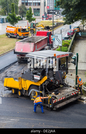 Innerstädtische Straßenbaustelle. Asphaltierte Arbeit an einer großen Straßenkreuzung. Neue Asphaltdecke. Alfred Str., B224 in Essen. Stockfoto