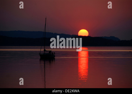 Dunkle rote Sonnenuntergang, einsamen Segelboot, silhouette, See Chiemsee, Chiemgau, Bayern, Oberbayern Stockfoto