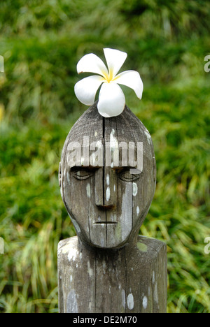 Balinesische snapshot, einfache Dekoration, Holz geschnitzte menschliche Figur, Frangipani (Plumeria) Blume auf seinem Kopf, Bali, Indonesien Stockfoto