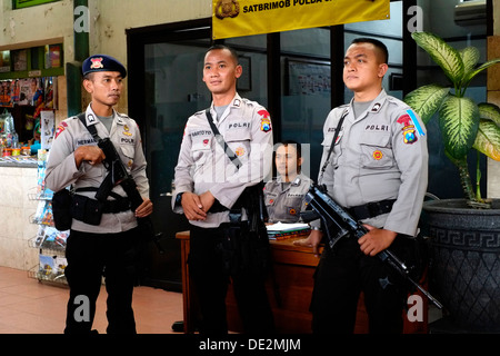 bewaffnete Polizei ein Auge auf Passagiere am belebten Bahnhof Malang während der anstrengenden Idul Fitri Urlaub Kurzurlaub Java Indonesien Stockfoto