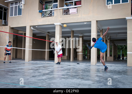 Männer spielen Takraw in einer Wohnsiedlung, Penang, Malaysia Stockfoto