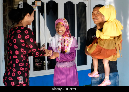 einheimische Frau Gruß an ihre Nachbarn, die traditionellen Feiertagen Idul Fitri besuchen Stockfoto