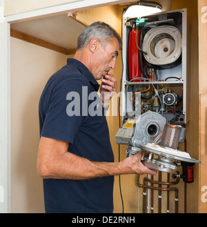 Ingenieur Wartung einen Gas-Brennwertkessel Stockfoto