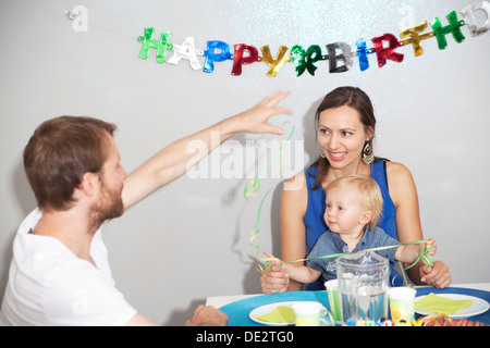 Eltern und ein Kind am Geburtstag des Kindes feiern Stockfoto