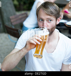Mann trinken Weizenbier in einem Biergarten Stockfoto