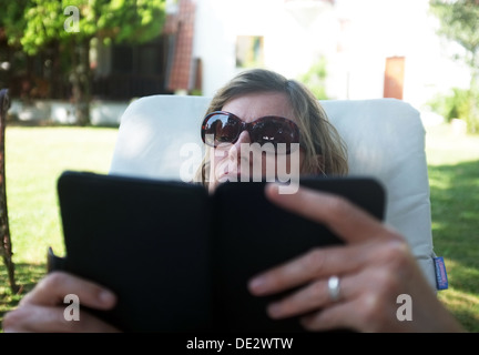 Frau liest ein Buch auf ihrem e-reader Stockfoto