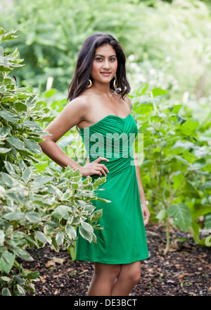 Junge Frau im grünen Kleid Garten Stockfoto