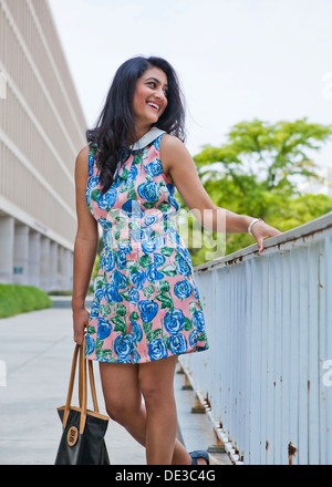 Junge Frau im urbanen Umfeld mit Blumenmuster einteiliges Kleid Stockfoto