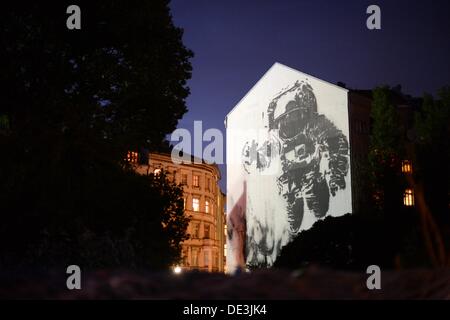 Ein riesiges Wandbild eines Astronauten vom portugiesischen Künstler Victor Ash sieht in der Dämmerung in Kreuzberg Bezirk von Berlin, Deutschland, 7. September 2013. Der Straßenkünstler schuf das Bild anlässlich der Backjumps Live Ausgabe 2007 in Berlin. Foto: Jens Kalaene Stockfoto