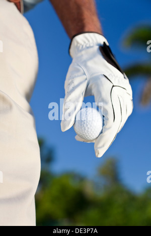 Hautnah am männlichen Golfer behandschuhten Hand hält einen Golfball Stockfoto