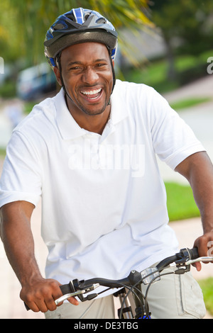 Ein schöner glücklich afroamerikanische Mann mit einem großen Lächeln auf seinem Fahrrad außerhalb Stockfoto
