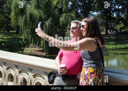Touristen auf Bogenbrücke im Central Park, New York Stockfoto